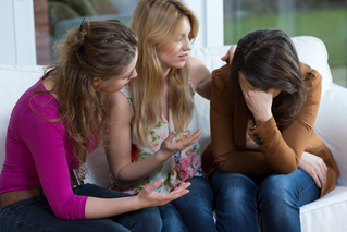 Women comforting upset woman