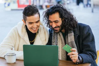 Two men at a cafe in winter, making donations online
